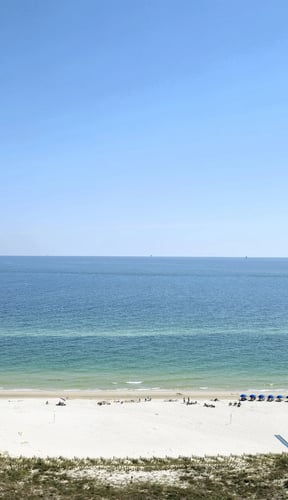 Aerial view of white sand beach and turquoise Gulf water in Gulf Shores