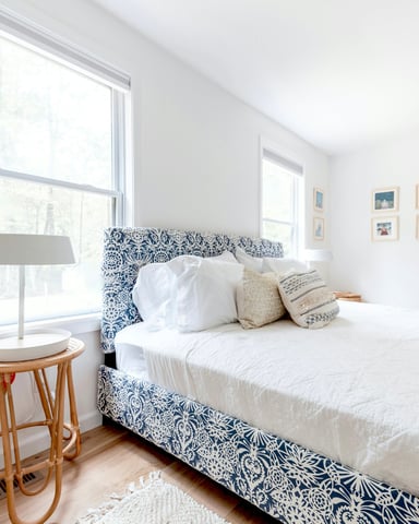 Bright coastal bedroom with blue floral headboard and natural light