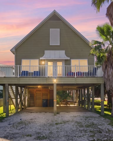 Row of colorful beach cottages on white sand