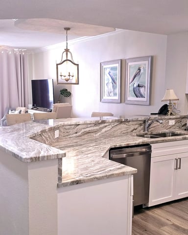 Open kitchen with marble counters and living area with Gulf view