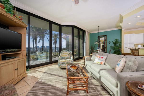 Covered waterfront porch with dining table, blue seating area, and expansive lake views with docks and distant shoreline